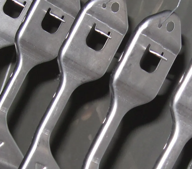 identical silver metal parts hanging next to each other identical silver metal parts hanging next to each other